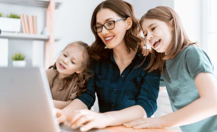 Donna davanti al computer con bambine