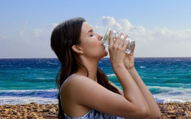 Donna beve sulla spiaggia