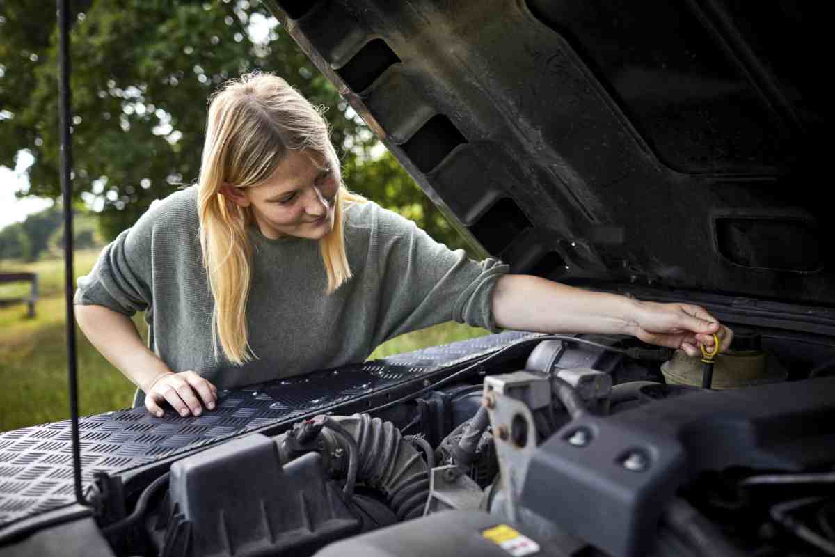 Donna controlla olio motore auto