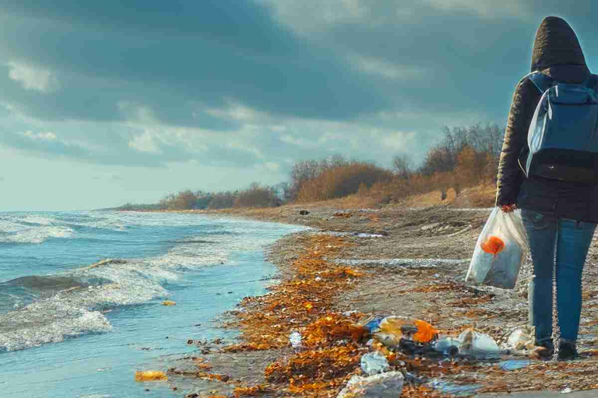 ragazza pulisce la spiaggia dai rifiuti