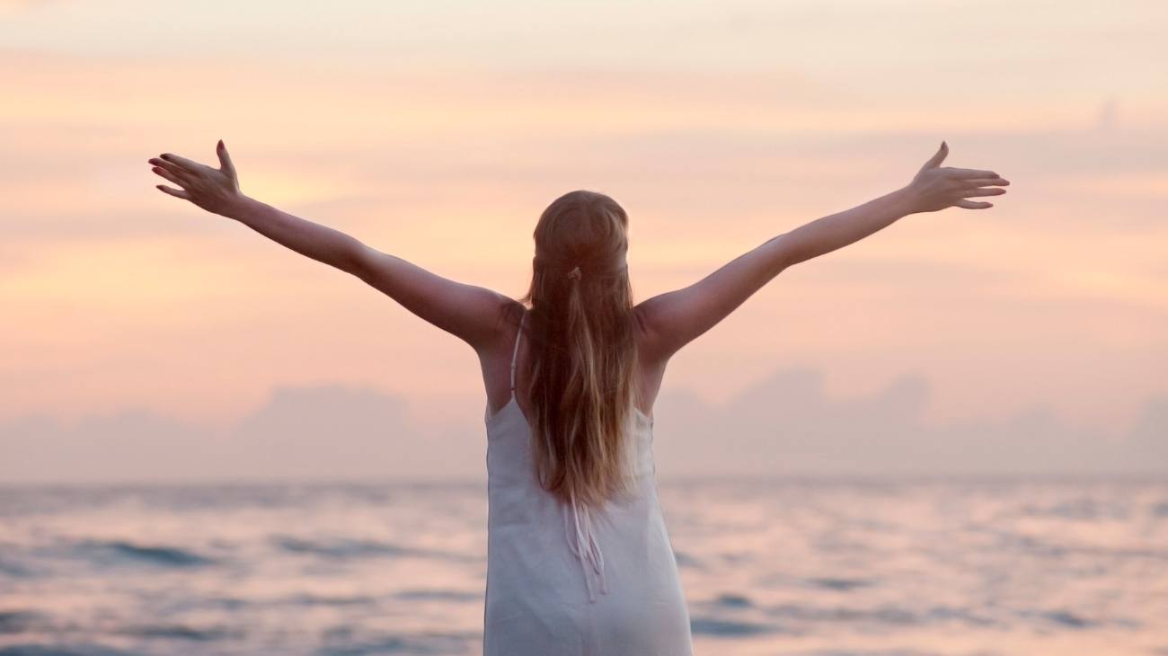 donna di spalle felice al mare