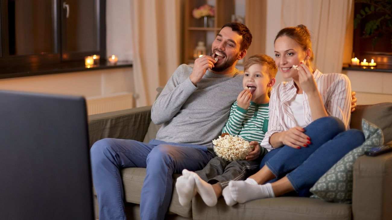 Famiglia guarda tv e mangia popcorn