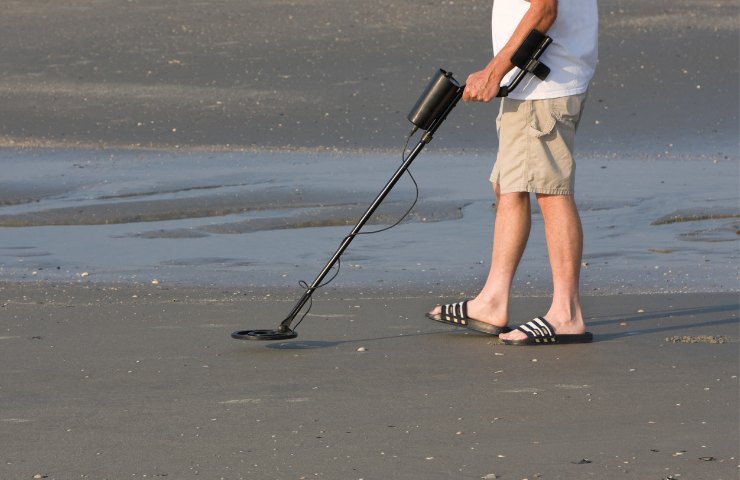 Cercare tesori nascosti metal detector spiaggia mare fiume