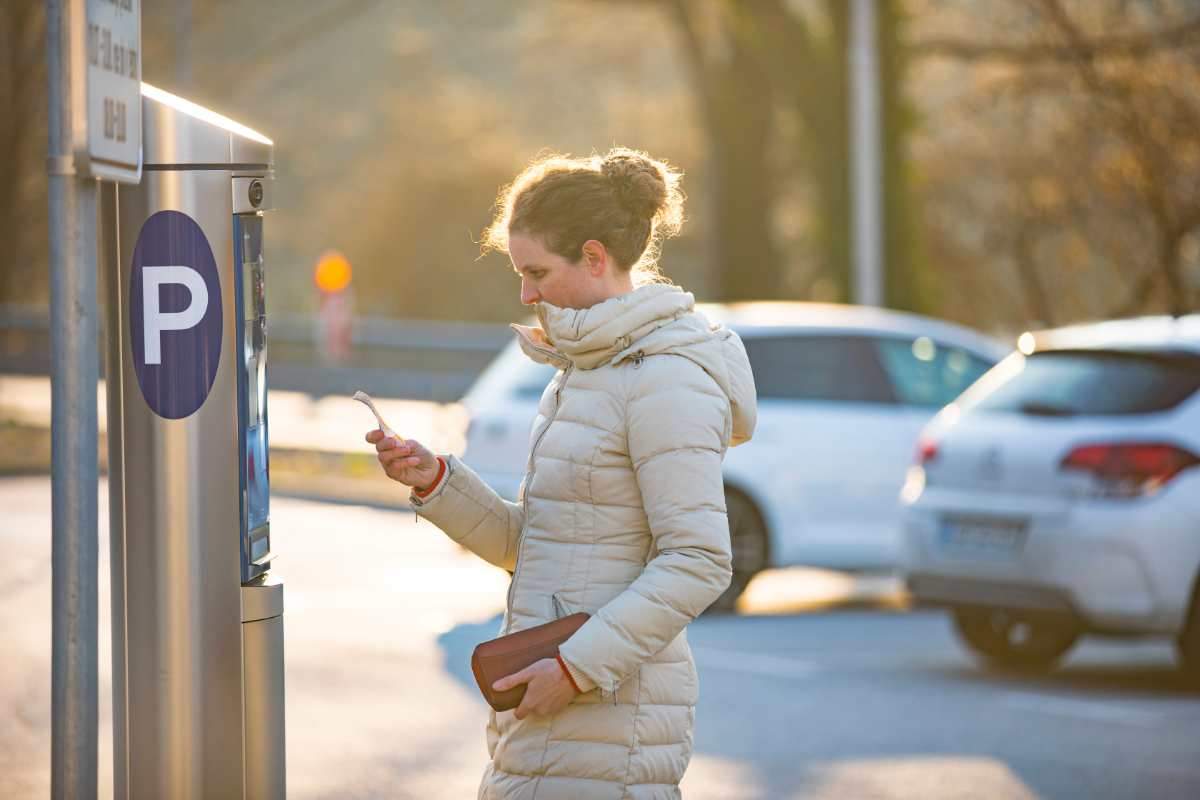 Donna che paga il tagliando per il parcheggio